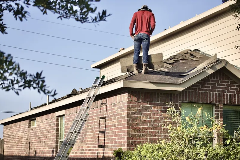 Professional roofer working on a residential roof in Gilliam